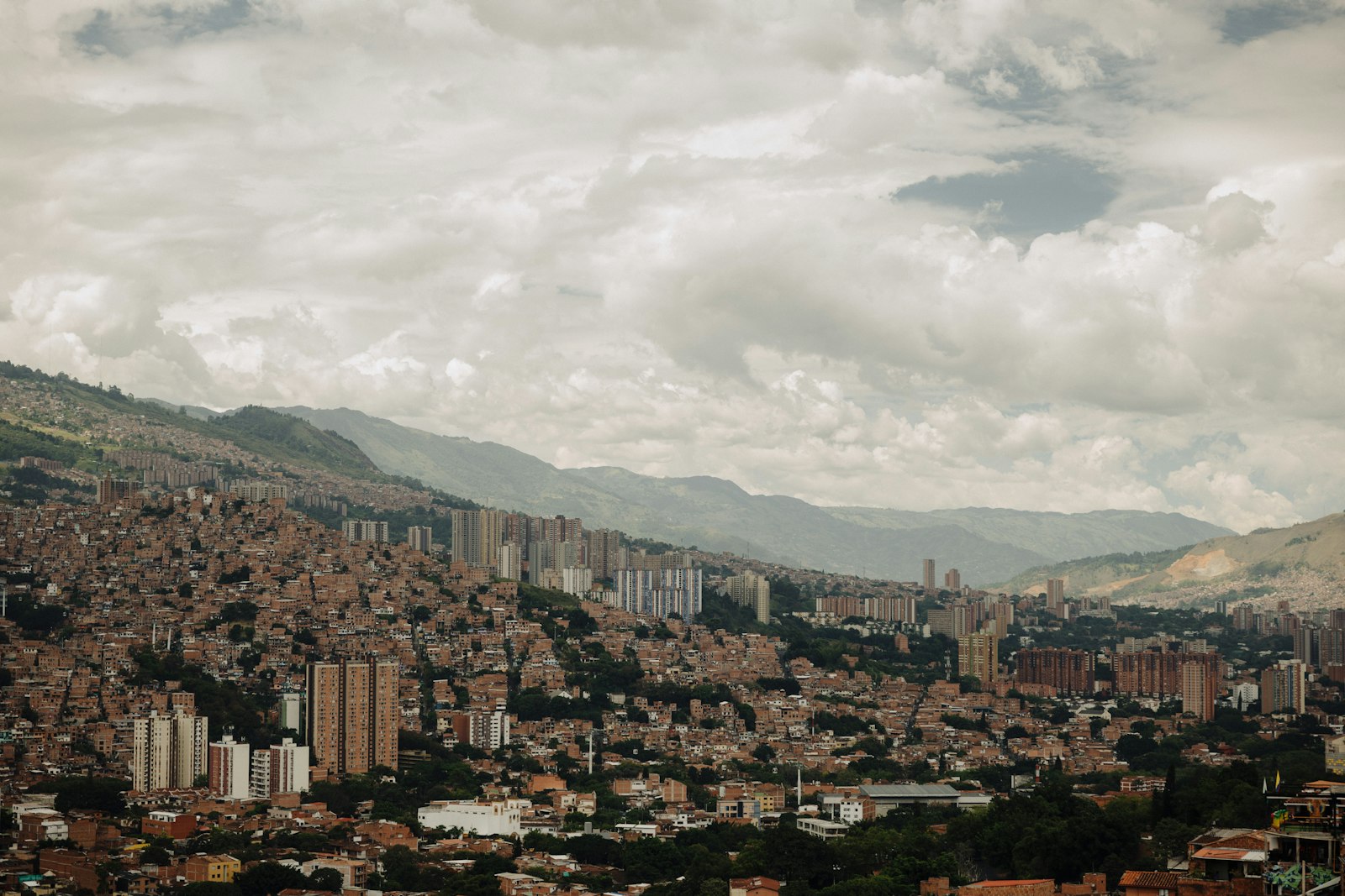 Aerial view of Medellín, Colombia, with dense hillside housing and green mountains